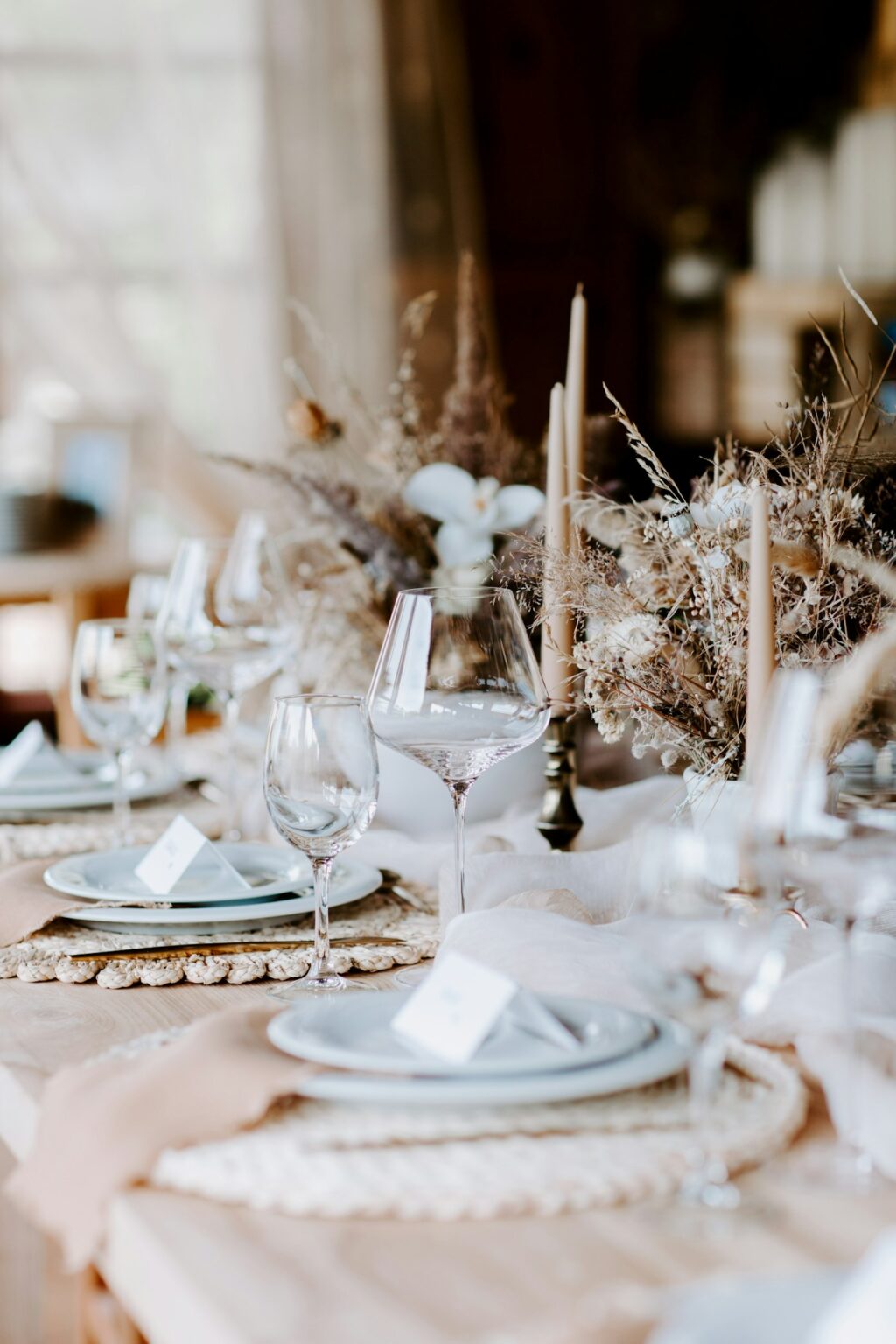 Styled table setting with stoneware, candles and dried stems